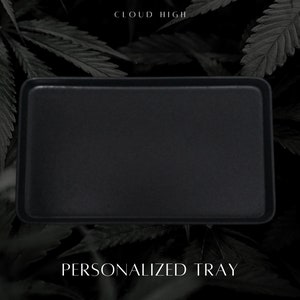 May include: Black rectangular tray with the text "CLOUD HIGH" and "PERSONALIZED TRAY" in white lettering. The tray is surrounded by dark green foliage.