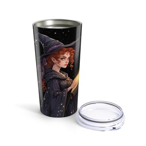 May include: A stainless steel tumbler with a black background and a colorful illustration of a witch with red hair wearing a black hat and a purple dress. The witch is holding a book and there are stars in the background.