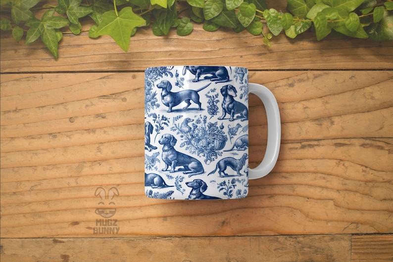 May include: White ceramic mug featuring a blue and white pattern of dachshunds and floral designs. The mug has a handle.