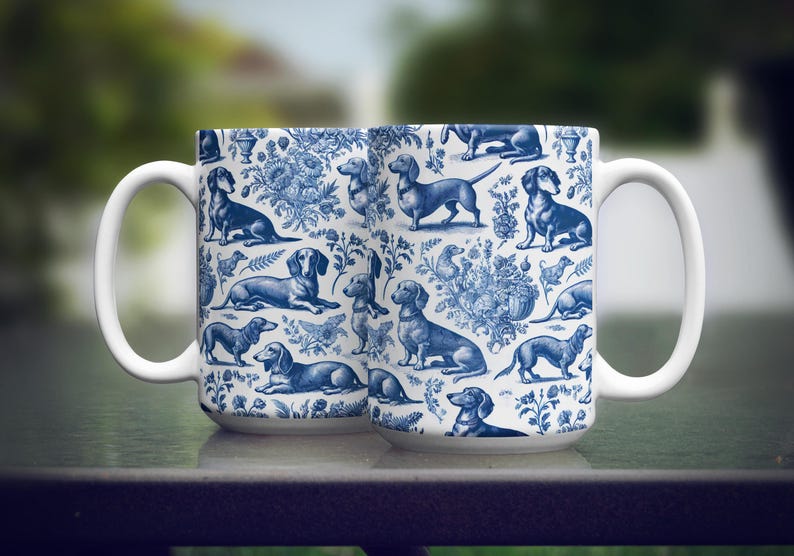 May include: Two white ceramic mugs featuring blue and white illustrations of dachshunds and floral designs.