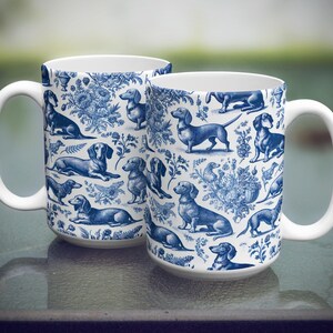 May include: Two white ceramic mugs with blue and white dachshund patterns. The mugs are 11 ounces and are dishwasher and microwave safe.