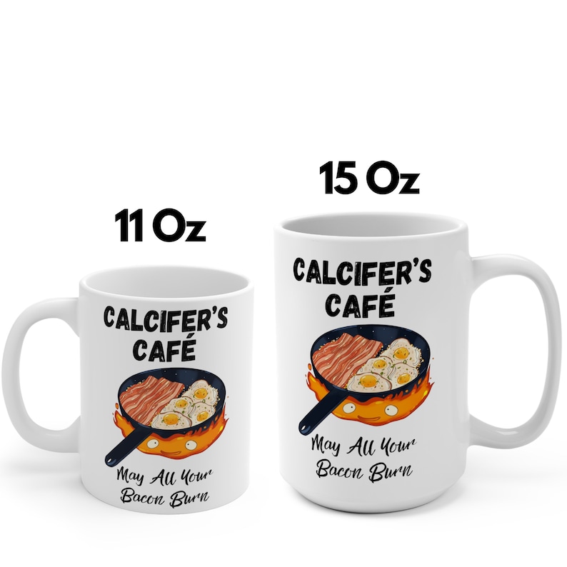 May include: White ceramic mug with a black and orange design. The mug features a cartoon image of a frying pan with bacon and eggs, with the text "Calcifer's Cafe" and "May All Your Bacon Burn". The mug is available in two sizes: 11 oz and 15 oz.