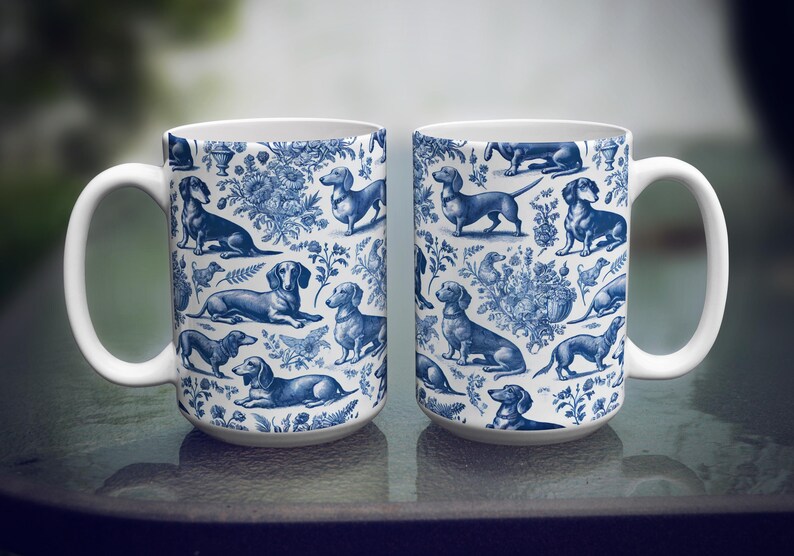 May include: Two white ceramic mugs with a blue and white pattern of dachshunds. The mugs have a handle on the right side.