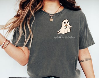 May include: A gray t-shirt with a cartoon ghost holding a flower and the text "spooky season".