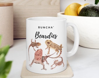May include: White ceramic mug with a black and white illustration of bearded dragons. The text "Buncha' Beardies" is printed on the mug.