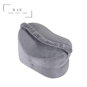 May include: A grey, wedge-shaped pillow with a zipped cover. The pillow is designed to provide support for the back and hips.