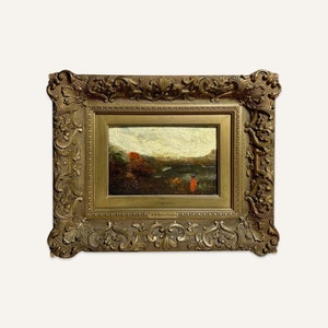 May include: A framed oil painting depicting a landscape scene with a lake, trees, and a figure in the distance. The painting is in a gold ornate frame.