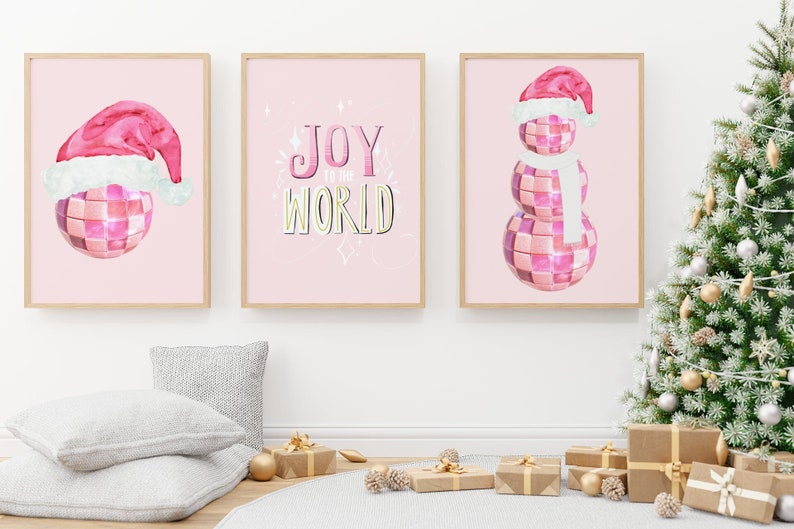 May include: Three pink and white Christmas-themed prints with a disco ball design. The first print features a Santa hat, the second print says "Joy to the World", and the third print features a snowman.