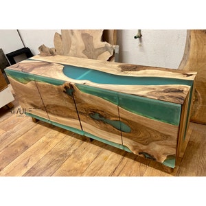 Può includere: Un mobile in legno con tre ante e un fiume di resina verde che scorre sulla parte superiore. Il mobile è in legno naturale con una finitura rustica.