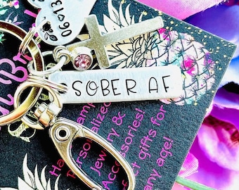 Llavero con dije y etiqueta personalizada, estampado a mano con la inscripción "SOBER AF".