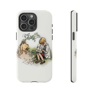 Könnte beinhalten: Weißes Handycase mit einer klassischen Illustration eines jungen Jungen, der ein Buch mit einem Bären liest. Das Buch trägt die Aufschrift "JAM". Das Case hat eine schwarze Kamera und Knöpfe.