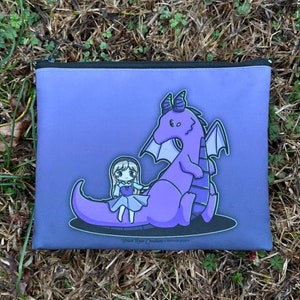 Pode incluir: Bolsa de zíper roxa com uma ilustração de desenho animado de uma menina montando um dragão roxo. O texto "Bear Heart Creations" está impresso na parte inferior da bolsa.