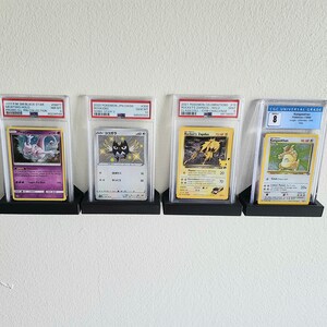 Puede incluir: Cuatro cartas de intercambio de Pok&eacute;mon se muestran en estuches protectores. Las cartas est&aacute;n calificadas por CGC Universal Grade y presentan a Mewtwo, Kokoara, Rocket's Zapdos y Kangaskhan. Las cartas est&aacute;n en excelente estado y tienen una calificaci&oacute;n alta.