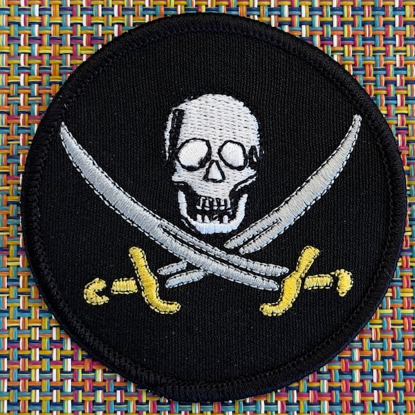 3" Skull and Crossed Swords patch in Gold and Silver metallic embroidery on Black background.    Finished edge patch to sew or glue on.