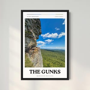 May include: A poster with a photograph of a rocky cliff overlooking a forest. The sky is blue with white clouds. The text "THE GUNKS SHAWANGUNK MOUNTAINS" is printed at the bottom of the poster.