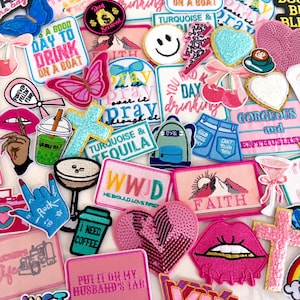 May include: A collection of assorted embroidered patches featuring various designs including butterflies, hearts, crosses, lips, coffee cups, and text-based slogans like 'It's a good day to drink on a boat', 'Faith', and 'WWJD' in vibrant colors.
