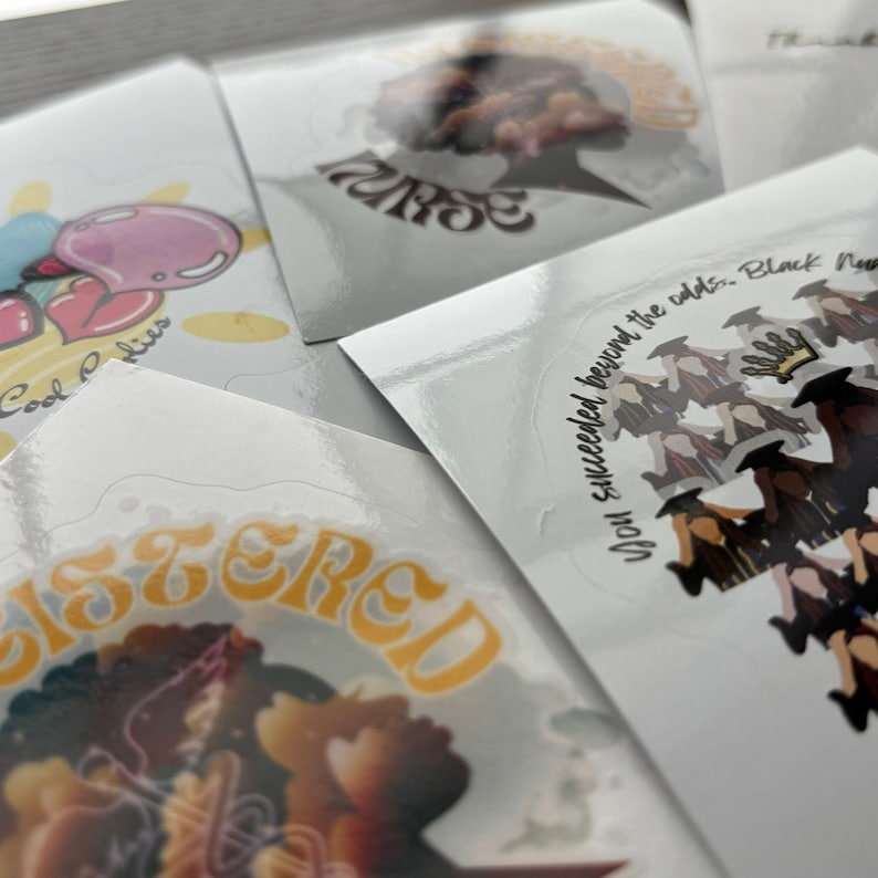 May include: A collection of glossy stickers with various designs and text. One sticker features the word "SISTERED" in orange script. Another says "Nurse" in a stylized font. A third sticker has the text "You succeeded beyond the odds. Black Nurses".