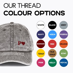 May include: A grey distressed denim baseball cap with a red embroidered letter 'P' and a heart. The cap is shown with a selection of thread colours for customisation.