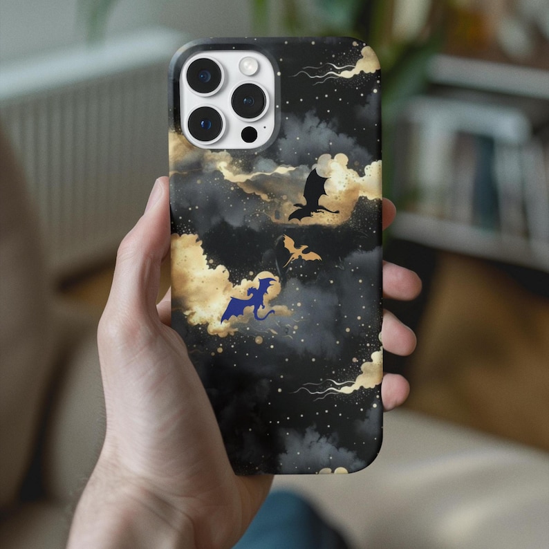 May include: A black phone case with a fantasy design featuring dragons and clouds. The case has a dark background with gold and white clouds, and silhouettes of dragons in flight. The design is repeated on the entire surface of the case.