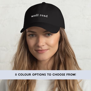 May include: A black baseball cap with white embroidery that reads "well read".