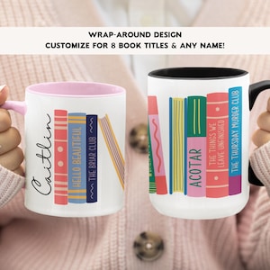 May include: Two white ceramic mugs with pink and black rims. The mugs feature a wrap-around design of colourful stacked books with book titles. One mug has the name "Caitlin" written on it. The text on the mugs reads: "Hello Beautiful", "~The Briar Club~", "ACOTAR", "The Things We Leave Unfinished", "The Thursday Murder Club".