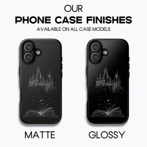 May include: Two black phone cases, one matte and one glossy, showcasing a white line drawing of a castle and an open book. The text at the top reads "OUR PHONE CASE FINISHES". The text at the bottom reads "MATTE" and "GLOSSY".