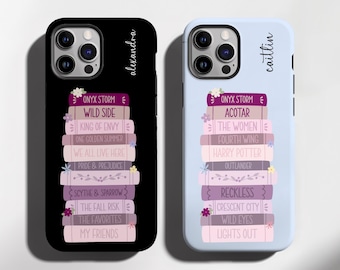 May include: Two phone cases, one black and one light blue, each featuring a stack of books with titles like "ONYX STORM" and "HARRY POTTER." The black case is labeled "alexandra," and the blue case is labeled "caitlin."