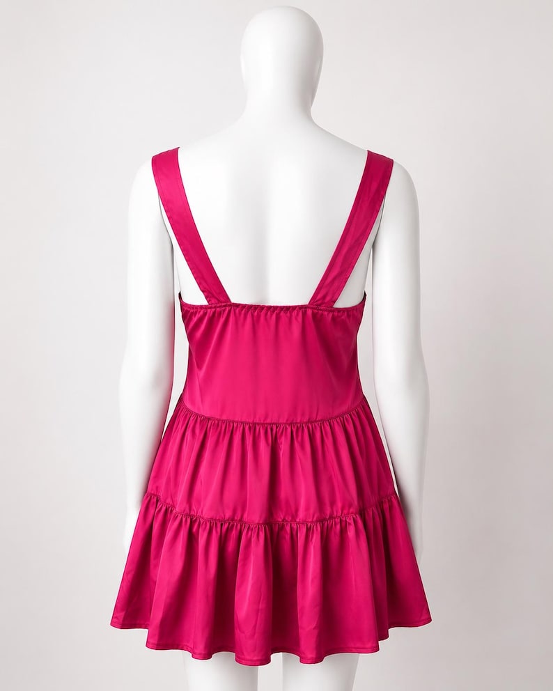 May include: A vibrant magenta sleeveless dress featuring a square neckline and wide shoulder straps. The garment is constructed with a fitted bodice that transitions into a two-tiered, gathered skirt, creating a flared silhouette with a smooth finish.