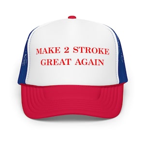 May include: A white and red trucker hat with a blue mesh back. The hat has the text "MAKE 2 STROKE GREAT AGAIN" in red letters.