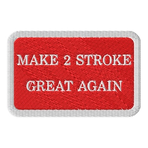 May include: Embroidered patch with the text "MAKE 2 STROKE GREAT AGAIN" in white on a red background. The patch has a rectangular shape with rounded corners and a gray border. The text is in a bold, sans-serif font.