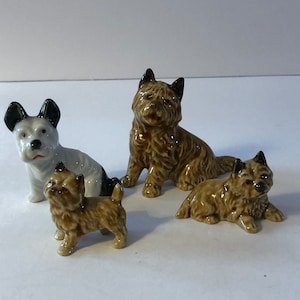 Miniaturas antiguas de perros terrier de porcelana. Lote de cuatro.