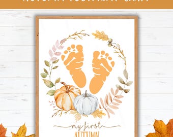 May include: A framed print with the text "AUTUMN FOOTPRINT CRAFT" at the top. The print features orange baby footprints, pumpkins, and fall foliage. The words "my first AUTUMN" are written at the bottom.