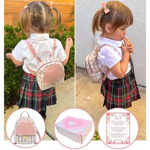 May include: A young child wearing a white collared shirt, plaid skirt, and a small backpack. The backpack is pink and beige with a flap closure. Additional images show the backpack, a heart-patterned box, and a framed poem.
