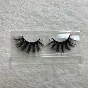 May include: Two pairs of black false eyelashes in a clear plastic case.