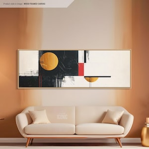 Può includere: Stampa d'arte astratta con forme geometriche nere, bianche, rosse e dorate. La stampa è incorniciata in legno e appesa a una parete sopra un divano bianco.