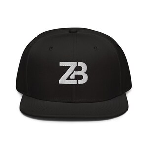 May include: Black baseball cap with a flat brim. The cap features a white embroidered "ZB" logo on the front. The hat is a classic style, suitable for casual wear.