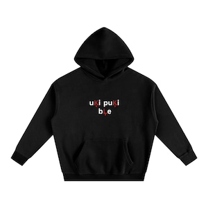 May include: Black hooded sweatshirt with a kangaroo pocket and drawstring. The text "uki puki ble" is printed in white and red on the front. The sweatshirt has long sleeves and a hood.