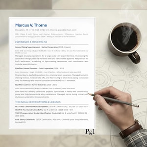 May include: A resume for Marcus V. Thorne is displayed on a desk, with a cup of coffee and a hand holding a pencil. The resume lists experience as a piping superintendent and pipefitter. The resume also lists technical certifications and licenses.