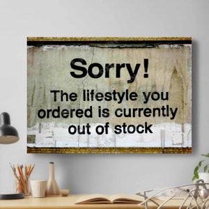 May include: A canvas print with the words "Sorry! The lifestyle you ordered is currently out of stock" in black text. The background has a distressed, aged appearance with a brick border.