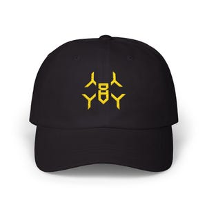 May include: Black baseball cap with a curved brim. The cap features a yellow embroidered design on the front. The design is a geometric pattern. The cap is made of a soft, durable material.
