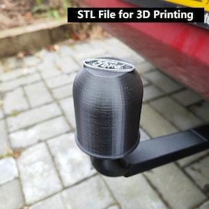 Könnte beinhalten: Ein schwarzer, 3D-gedruckter Anhängerkupplungsschutz mit einem silbernen Ford-Logo. STL-Datei zum 3D-Druck.