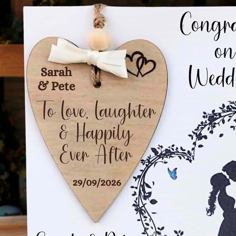 Pu&ograve; includere: Una targa in legno a forma di cuore con un fiocco color crema, una perlina di legno e un testo inciso in marrone scuro che recita Sarah & Pete, To love, laughter & Happily Ever After, e la data 29/09/2026, con due piccoli cuori incisi.