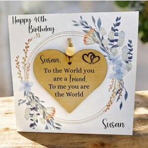 May include: A decorative wooden plaque with a heart-shaped centre. The plaque features the text "Happy 40th Birthday Susan" and a heartfelt message. Floral designs and the name "Susan" are also visible.