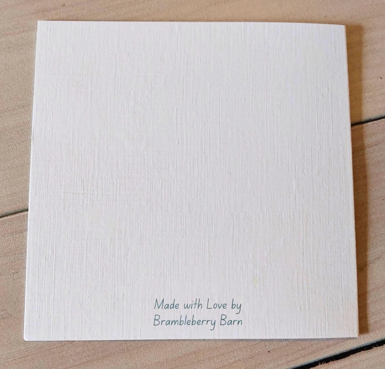 Pu&ograve; includere: Un cartoncino quadrato bianco con una superficie testurizzata. Nella parte inferiore centrale del cartoncino &egrave; presente il testo stampato "Made with Love by Brambleberry Barn" in un semplice carattere sans-serif grigio scuro su fondo bianco.
