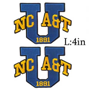 K&ouml;nnte beinhalten: Zwei blau-goldene gestickte Aufn&auml;her. Jeder Aufn&auml;her zeigt ein gro&szlig;es blaues "U" mit "NC A&T" in goldfarbenen Buchstaben und dem Jahr "1891". Die Aufn&auml;her sind etwa 10 cm lang.