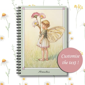 May include: A green spiral bound notebook with a vintage illustration of a fairy holding flowers. The text "Amelia" is printed at the bottom of the notebook.