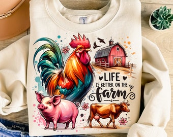May include: A white sweatshirt with a colorful illustration of a rooster, pig, and cow on a farm. The text "Life is better on the farm" is written in a whimsical font.