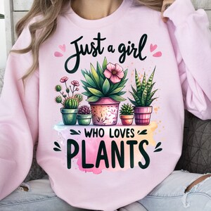 Może przedstawiać: R&oacute;żowa bluza z napisem "Just a girl who loves plants" i akwarelowym wzorem doniczkowych roślin.