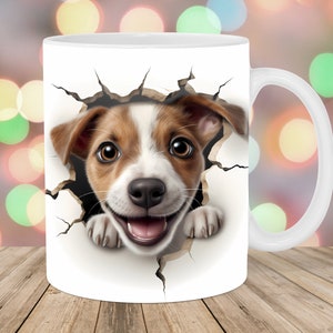 Pode incluir: Caneca de cerâmica branca com um cachorrinho marrom e branco espiando por um buraco na caneca. O cachorrinho tem uma expressão feliz e está olhando diretamente para o espectador.