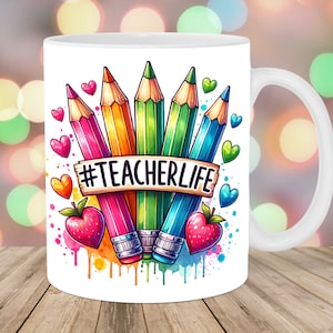Può includere: Tazza in ceramica bianca con un'illustrazione colorata di matite e cuori. Il testo "#TEACHERLIFE" è scritto su uno striscione.